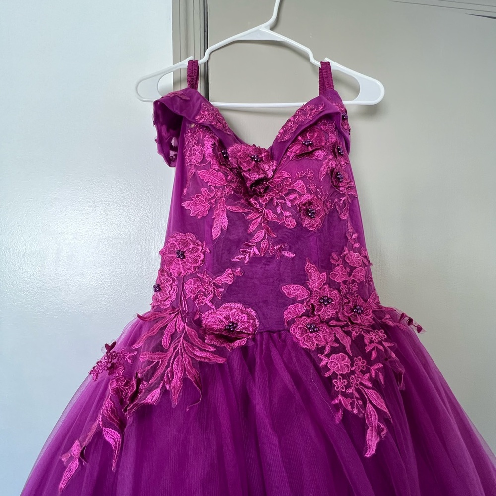 This is a deep plum gown. Perfect for prom, quince, or special occasion!